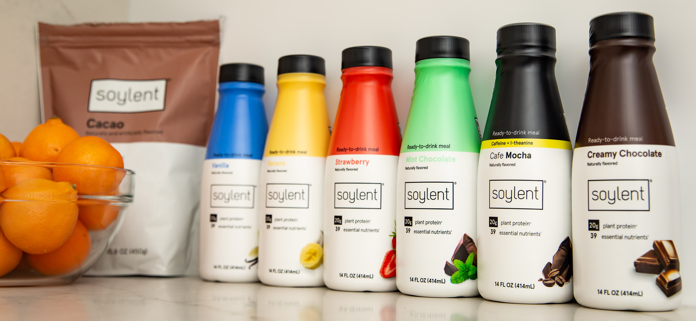 All of Soylent meal replacement drink flavors on a purple background