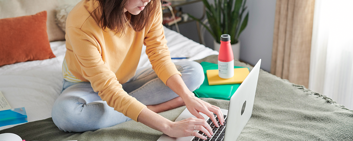 Student working in dorm room with Soylent by her side